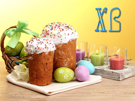 Beautiful Easter cakes, colorful eggs in basket and candles